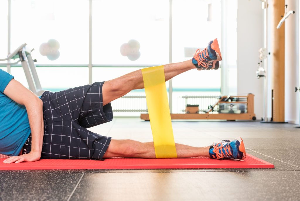 Patient doing a leg exercise with a resistance band at STADS