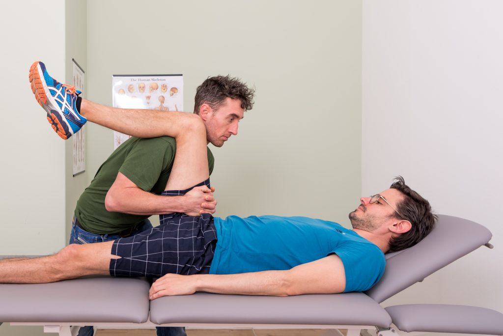 Physiotherapist assessing a patient lying on a treatment table at STADS
